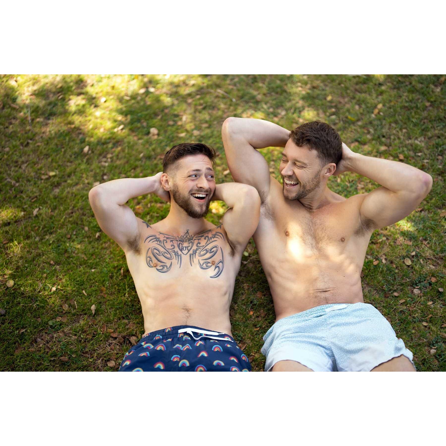 Two topless males posed lounging outdoors