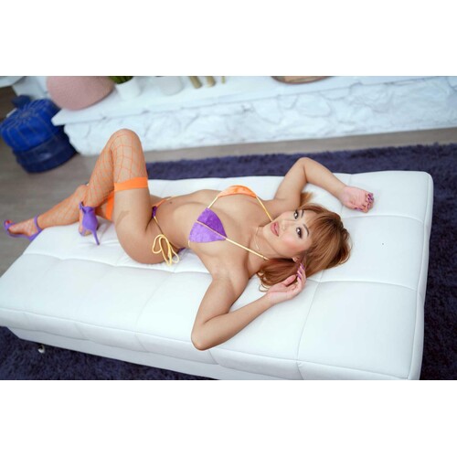 Brunette female lounging wearing bikini displaying cleavage