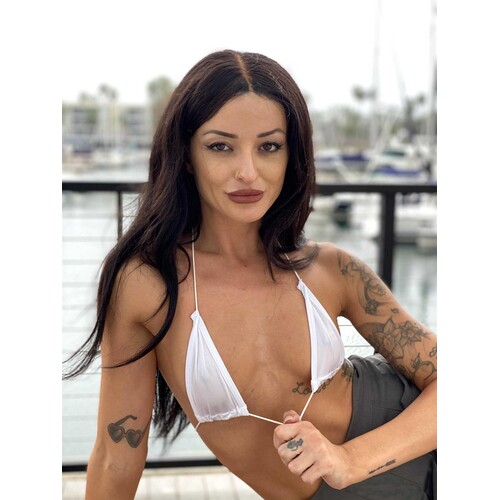 Brunette female posed outdoors wearing bikini displaying cleavage